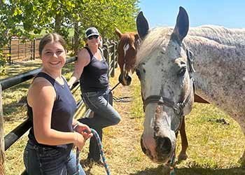 Dal Porto Equestrian team members relaxing with horses at show March 2023